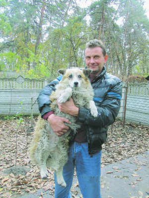 Андрій Сабалдаш, чоловік волонтера Ірини Сабалдаш стоїть із собакою Мухою. Зараз вона на тимчасовому утриманні зоозахисників. Їй шукатимуть господаря