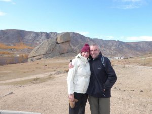 Філ та Емма позують на фоні скелі в Монголії