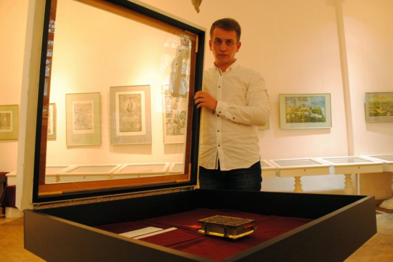 Станислав Волощенко показывает старопечатное издание на выставке в Музее книги и печати Украины