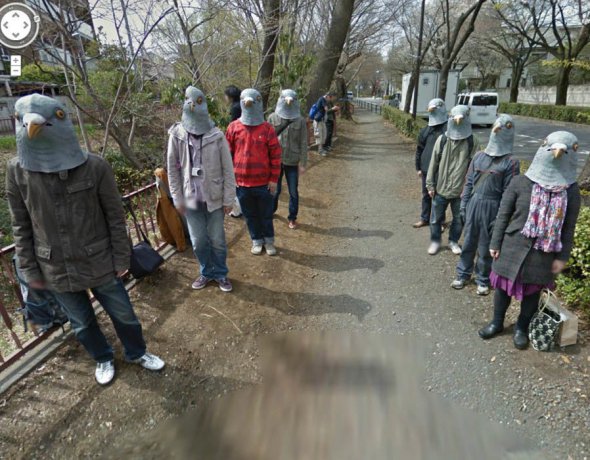Люди в масках голубей идут по улице. Япония.