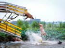 Свиней викидають з платформи в воду під час щоденного навчання на свинофермі в Шеньяні, провінція Ляонін, Китай, серпень 2017 р.