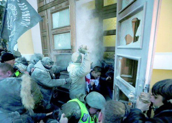 Учасники маршу за імпічмент президента прориваються в Жовтневий палац 17 грудня в Києві. Там хочуть облаштувати координаційний штаб. Їх зупиняють поліцейські та нацгвардійці