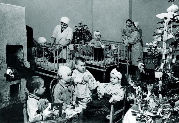 Діти розглядають новорічну ялинку в лікарняній палаті в блокадному Ленінграді 31 грудня 1941 року