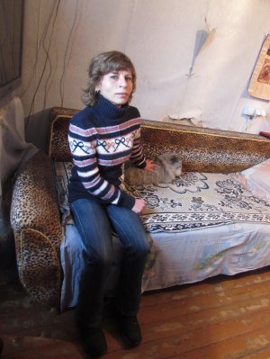 Катерина Григоренко сидить із котом на своєму ліжку в гуртожитку на вулиці Пушкіна в Полтаві. За кімнату вдвох із сусідкою платять 1350 гривень