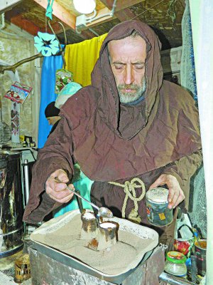 Олександр Мельничук готує каву на новорічному ярмарку у Вінниці. Кладе у напій часник, м’яту, грецький горіх або бадан