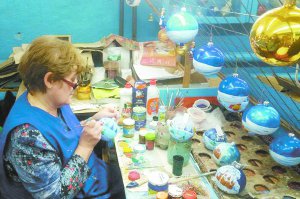Працівниця Клавдієвської фабрики ялинкових прикрас, що під Києвом,  розмальовує іграшку. На зміні трудяться 10 художників