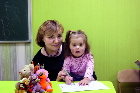 Олена БОЛЬШАНІНА, 41 рік, міжнародний економіст. Народилася у Василькові на Київщині у сім’ї інженерів. Закінчила лінгвістичний та економічний університети у столиці. 17 років працювала в міжнародній компанії. Була секретарем і керівником кількох відділів. Кинула роботу після народження другої дитини. Із сім’єю переїхала до Борисполя під Києвом. ”Побудували дачу за містом. Коли народилася Іванка, вирішили пожити там півроку. Сподобалося. До Києва повертатися не хочемо”. Любить займатися рукоділлям. Останнім часом захоплюється декупажем – технікою декорування. Чоловік Олексій – психолог-психотерапевт. Мають доньок – 5-річну Надію і 3-річну Іванку. На фото: Олена Большаніна обіймає доньку 3-річну Іванку у приватному садку Борисполя на Київщині. Дівчинка відвідує його останні півроку