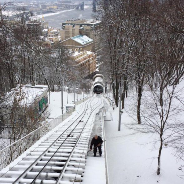 Киянин прибирав лопатою сніг з дороги фунікулера
