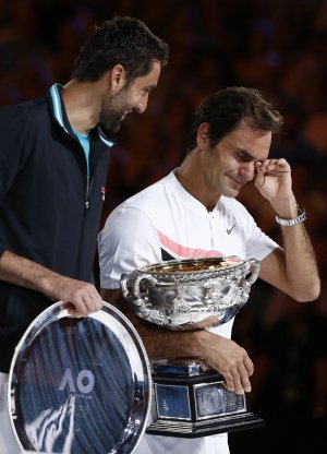 Роджер Федерер, праворуч, з призом переможця відкритого чемпіонату Австралії. Поруч стоїть Марин Чиліч — фіналіст турніру