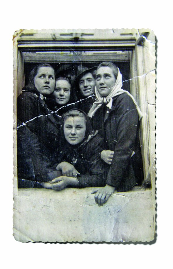 Марія Повх (у центрі) спирається на вікно у читальні товариства ”Просвіта”. Фото зроблене 1942 року в селі Перегноїв Золочівського району Львівської області