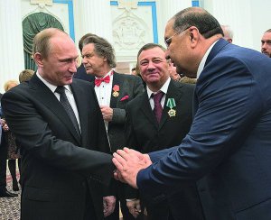 Володимир Путін вітає олігарха Алішера Усманова із врученням йому ордена ”За заслуги перед Отечеством”. Між ними — усміхається мільярдер Аркадій Ротенберг. Обидва потрапили до санкційного списку США. Кремль, жовтень 2013 року