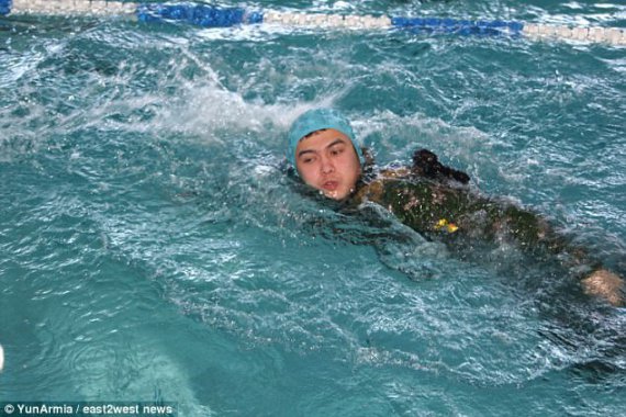 Новые фото изображают соревнования по плаванию с автоматом Калашникова на спине