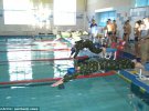 Останні фото зображують змагання з плавання з автоматом Калашнікова на спині