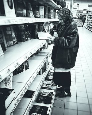 Анастасія Шевченко листає книжку в букіністичному відділі гіпермаркету ”Ашан”. Приходить туди на весь день відразу після відкриття впродовж 15 років