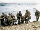 Члени американської десантної команди тягнуть людей до берега після того, як їх посадкові судна були затоплені нацистськими обстрілами біля берегів Франції