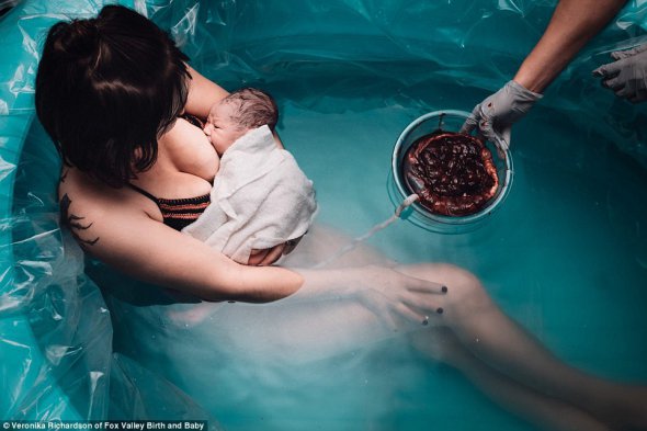 Мать впервые кормит только что родившегося младенца