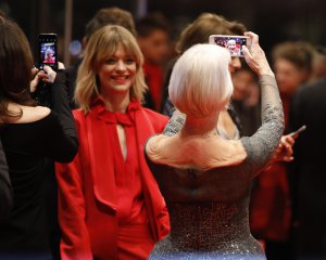 Англійська актриса 72-річна Гелен Міррен (стоїть спиною) фотографує себе на червоній доріжці 68-го Берлінського кінофестивалю в столиці Німеччини