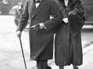 Вінстон Черчилль у циліндрі, довгому пальті та з тростиною йде з дружиною Клементиною до Вестмінстерського абатства в Лондоні, 1930 рік