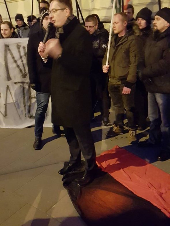 Посол польского Сейма Роберт Винницкий положил на землю красно-черный флаг и стал на него.