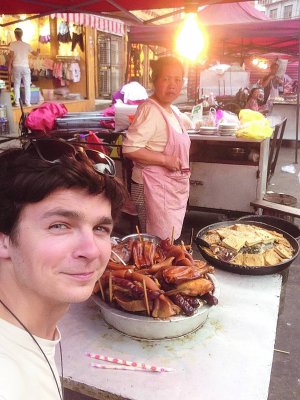 Киянин Олександр Ткачинський куштує соєвий сир тофу і традиційну свинину в китайському Ухані влітку 2016 року