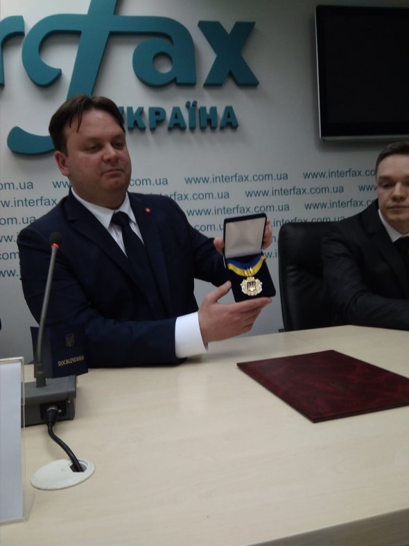 Ілля Лупоносов демонструє медаль "Почесний громадянин Одеси"