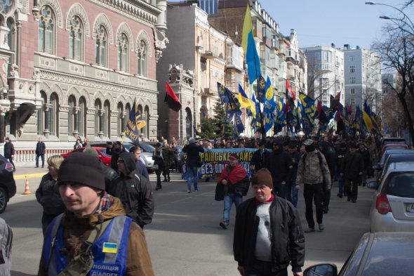 Участники марша националистов идут мимо Нацбанк в гости к президенту Порошенко