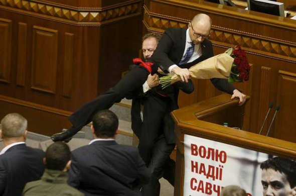 Нардеп фракції "Блок Петра Порошенка" Олег Барна  дарує вже екс-прем'єру квіти та намагається винести його з зали засідань. 
