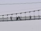 Участники из Китая, России и Украины переносили 200-килограммовые шины по самому длинному стеклянному мосту в мире.