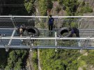 Участники из Китая, России и Украины переносили 200-килограммовые шины по самому длинному стеклянному мосту в мире.