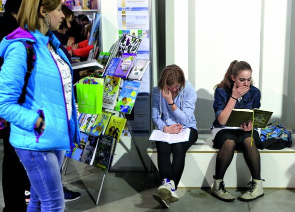 Відвідувачки читають книжки мовами національних меншин України біля стенда ”Дискусія” на ”Книжковому Арсеналі” 2017 року