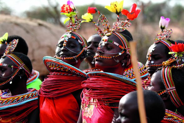Жінки виконують національний танець племені масаї. В їхньому одязі традиційно переважає яскравий червоний колір -  так відлякують хижаків