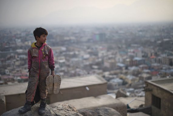 Афганський хлопчик, який заробляє на життя тим, що чистить взуття, дивиться зі схилу на кладовище Карта-е-Сакхи, Кабул, 10 лютого 2015 року. 