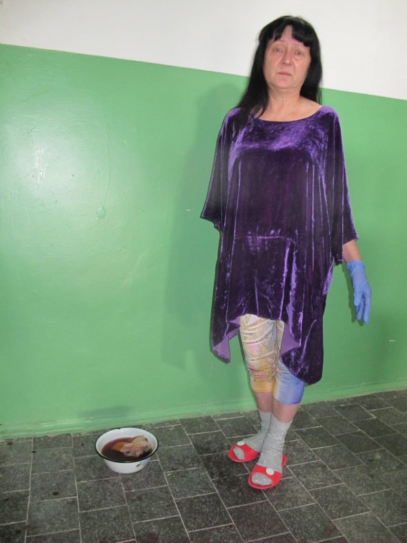 Сусідка подружжя Столбових, яких вбили в ніч на 27 квітня, відмиває стіни під'їзду від крові