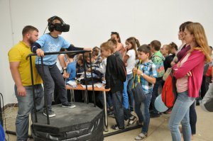 Відвідувач Дитячого форуму видавців у Львові на атракціоні віртуальної реальності вдягнув 3-D окуляри. В них бачить себе на американських гірках