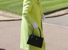 Королева Елизавета II прибыла на свадьбу в светло-салатовом пальто и капелюшци. Головной убор украшали фиолетовые цветы