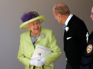 Королева Елизавета II прибыла на свадьбу в светло-салатовом пальто и капелюшци. Головной убор украшали фиолетовые цветы