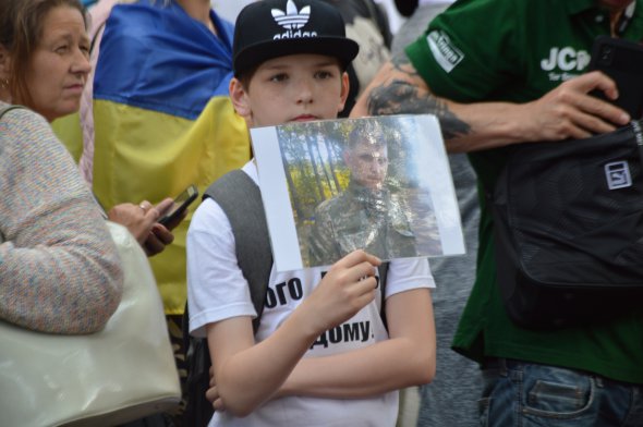 Хлопчик тримає фото танкіста Богдана Пантюшенка, яке у полоні з 2015 року