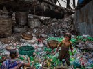 Під мостом в Бангладеш родина видаляє етикетки з пластикових пляшок, сортує зелені і прозорі пляшки і продає торговцю брухтом. Збирачі сміття заробляють 100 дол. на місяць.