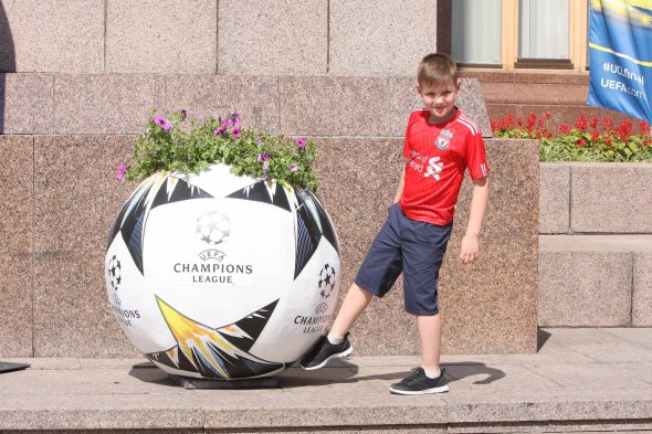 Юный фанат "Ливерпуля" увидел оригинальную вазу стилизованную под официальный мяч Лиги чемпионов и быстро фоткаться. Главное - с улыбкой на лице. Как иначе - в Киеве праздник