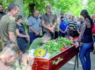 Побратими стоять навколішки біля труни загиблого бійця В’ячеслава Куцмая. Його поховали на алеї Героїв у Києві 25 травня