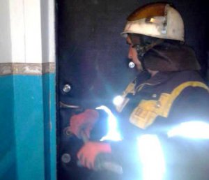 Спасатели открывают дверь квартиры, где остались два ребенка