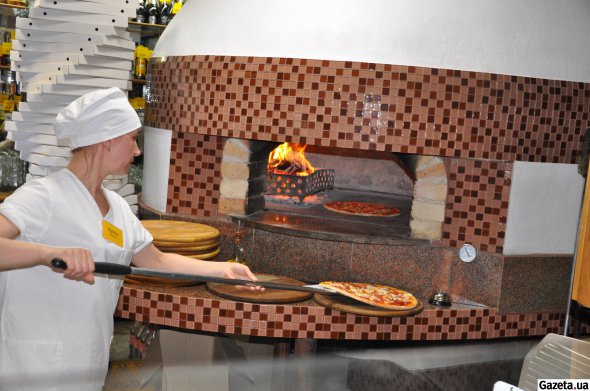 Мастер-пиццайоло Ирина Лесникова готовит пиццу в пиццерии "Юность" в Глухове