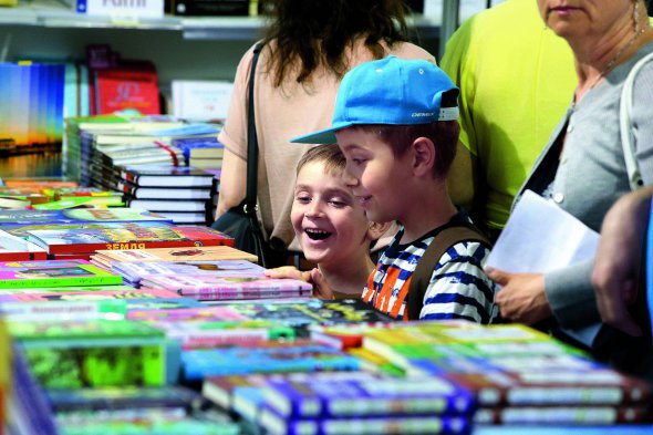 Юні відвідувачі ”Книжкового Арсеналу” роздивляються новинки на стенді київського видавництва ”КМ Букс”