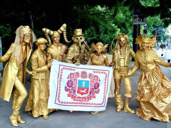 Живые статуи в стиле стим-панк от уличного театра "Джайра" позируют с флагом родного города Черкассы.