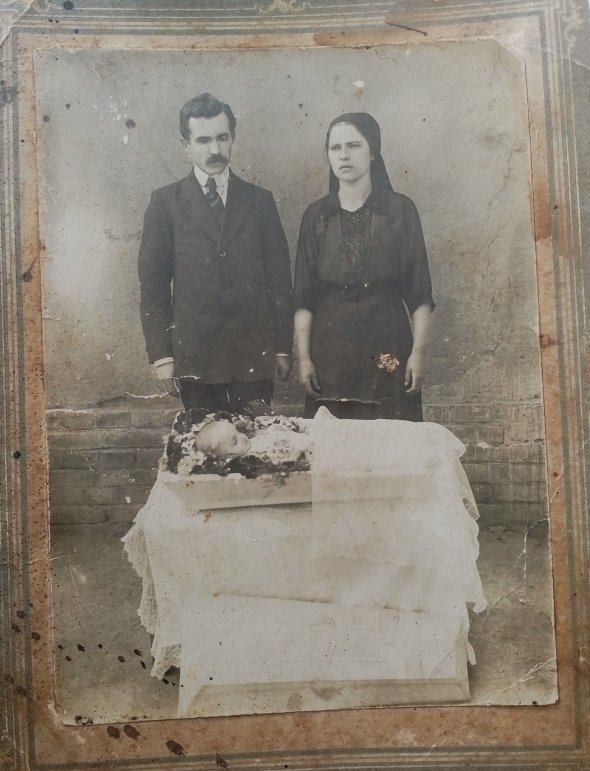 Родители фотографируются у гроба своего ребенка