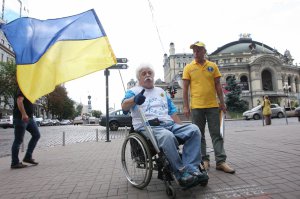 Киянин Микола Подрезан їде центром столиці. Світом мандрував з українським прапором і факелом з олімпійським вогнем