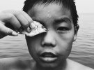 Изображение «Око за око». Показывает мальчика на берегу моря в провинции Янтай Шандонг, Китай. Автор: Хуапенг Чжао
