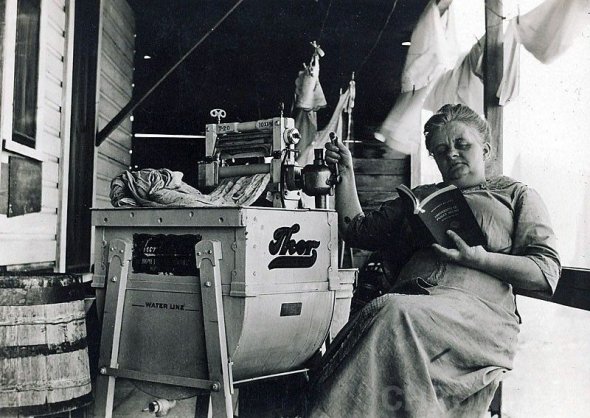 Домогосподарка демонструє зручність першої електричної пральної машини. Фото: chrontime.com