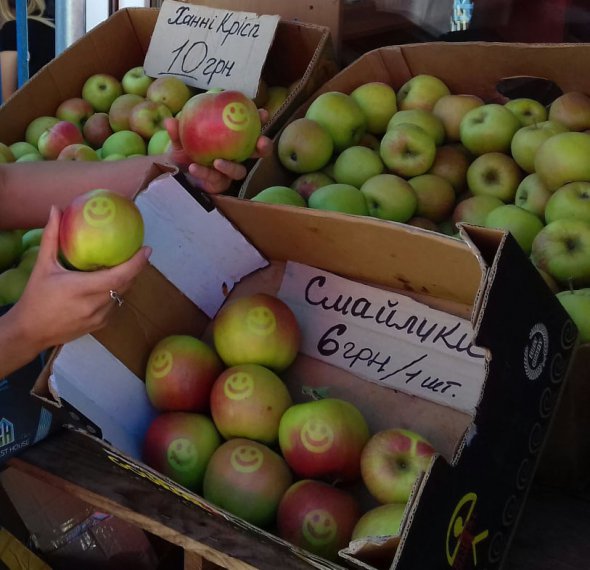 На ринку “Урожай” міста Вінниця почали продавати яблука із зображенням смайликів. Їх охоче беруть дітям. 