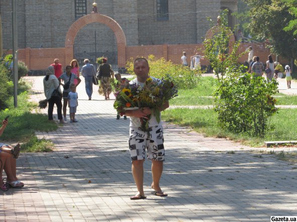 48-летний Виктор Кондратюк несет освящен охапку цветов и трав из храма